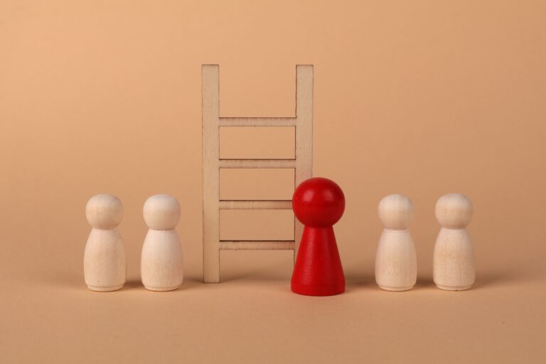Abstract representation of standing out from the crowd with wooden figures and ladder on a neutral background.